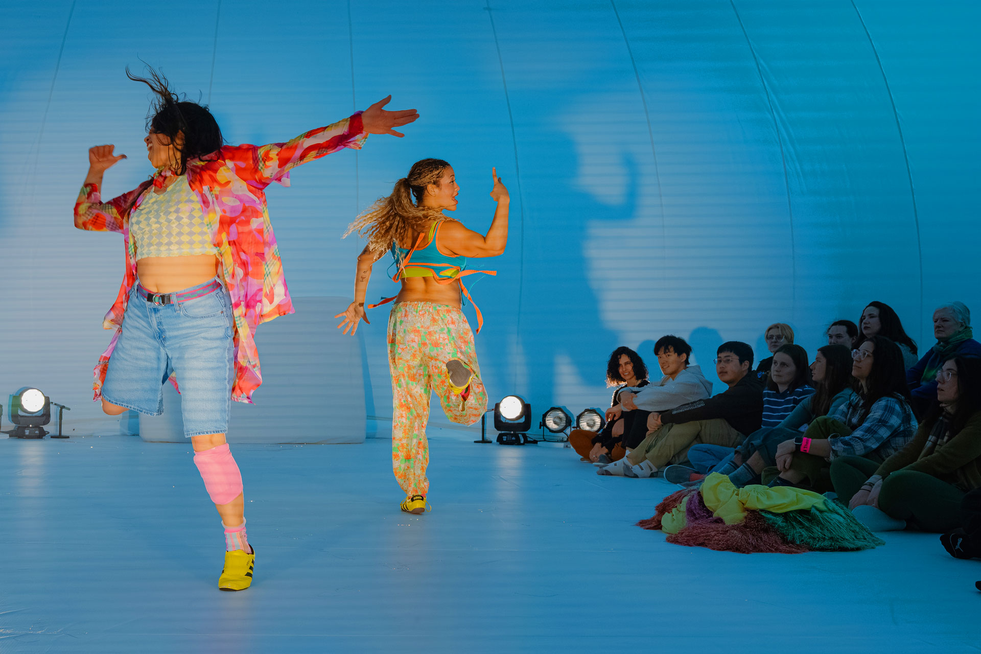 Dancers performing inside of a large tent and performance space.