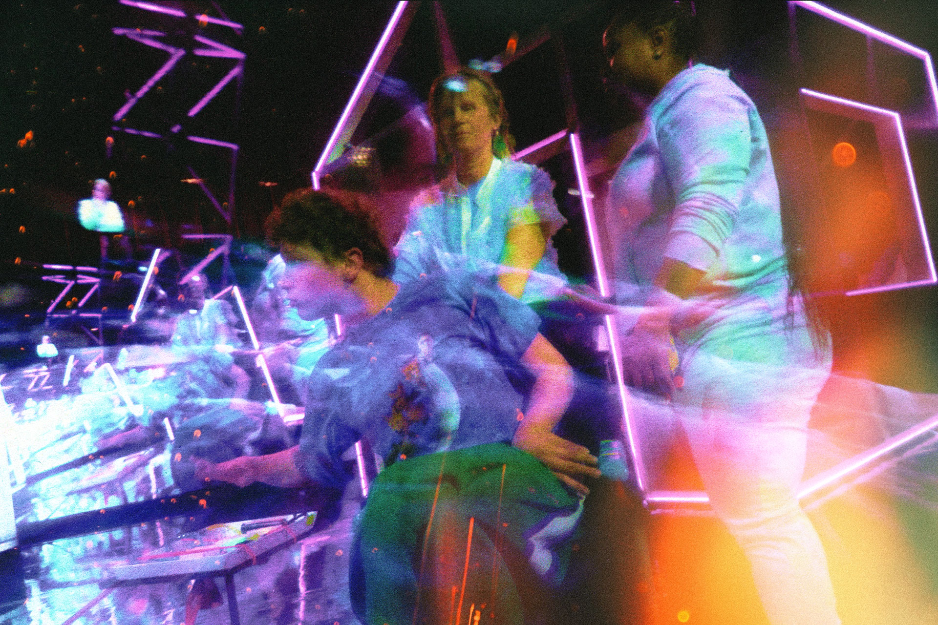 SENSORIUM EX. Differently abled performer being attended to by other performers on a high-tech, futuristic stage set.