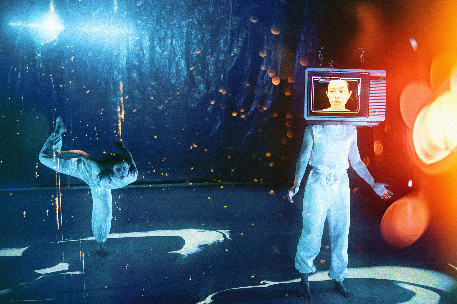 Student dancers. The one at right has a television set on her head with an image of her face on the screen.