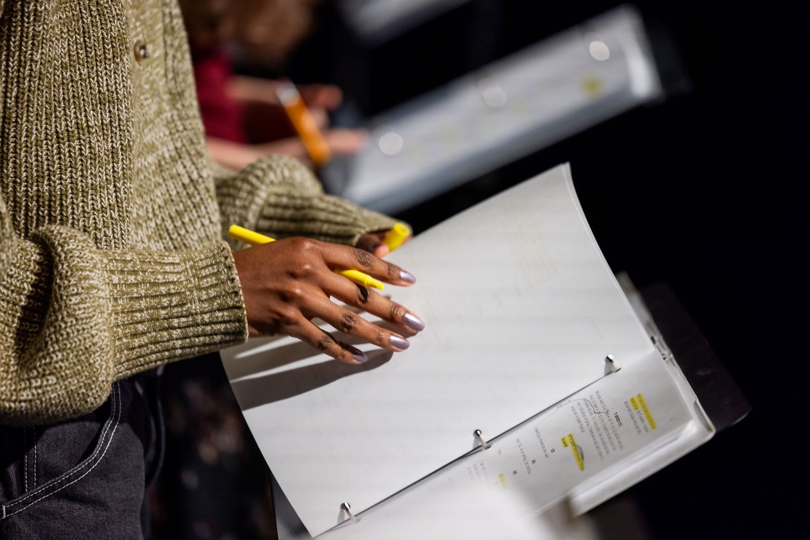 Script writer holding binder and highlighter.